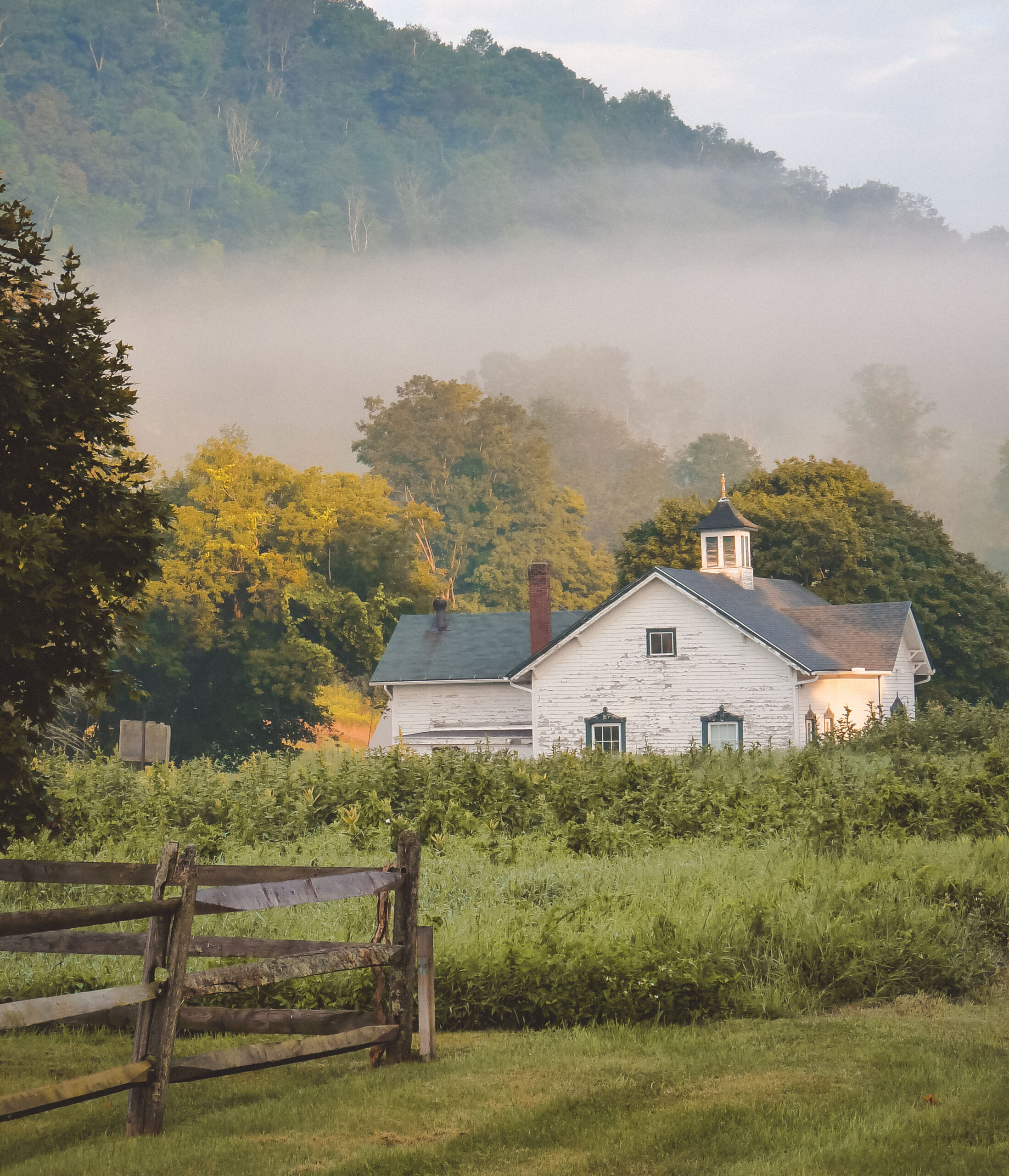 Photograph of the Tyringham Historical Society from a distance. The paint is peeling and the building is in need of repair.